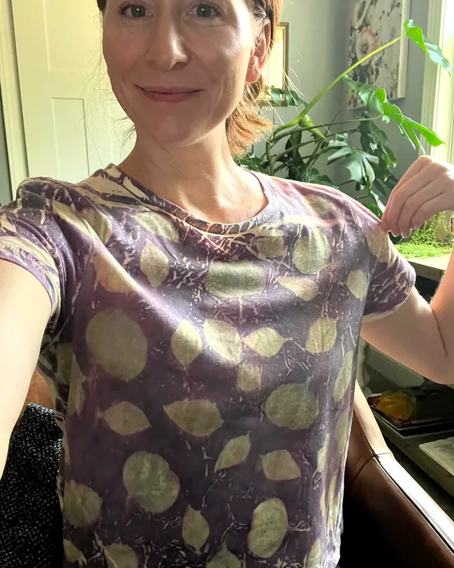 Maker in a plum-purple tee covered all over in soft green leaf prints made from real leaves